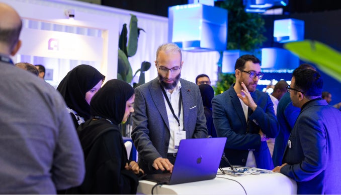 Attendees at the World Summit AI visit the HBKU booth