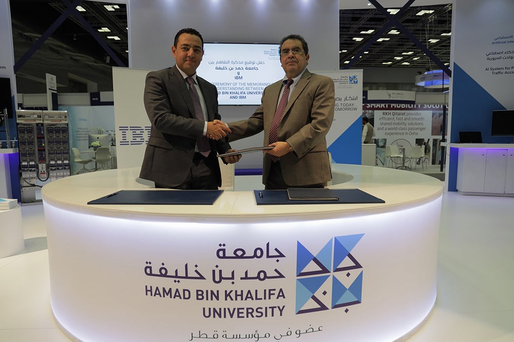 Dr. Mounir Hamdi, Dean of the College of Science and Engineering, and Mejdi Al Khater, Country Manager of IBM, signing at the HBKU booth.