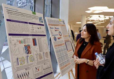 QBRI and CHLS researchers exchange feedback on each other’s research posters at the event.